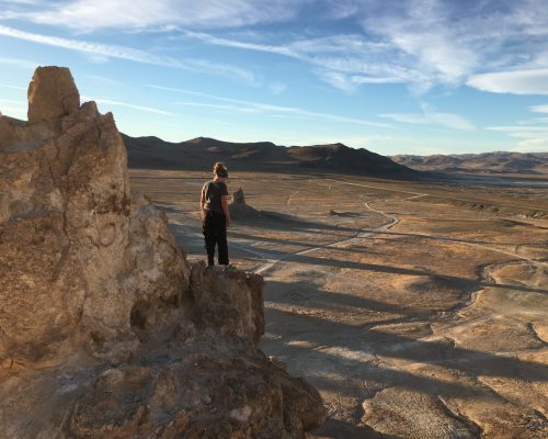 Girl on top of rock overlooking the desert