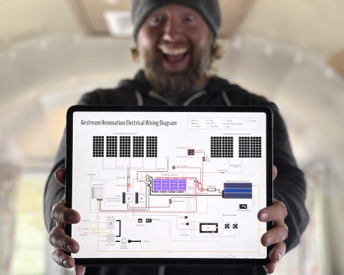 Man holding Airstream renovation electrical wiring diagram on an iPad
