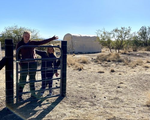 Adali and Ada standing in front of new pig paddock and feed shed.