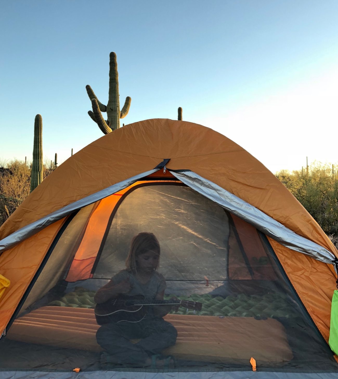 Girl playing ukulele in tent