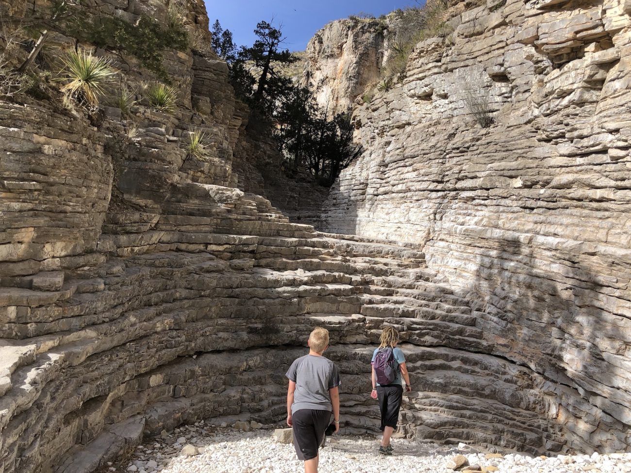 Kids climbing natural staircase at Devil's Hall