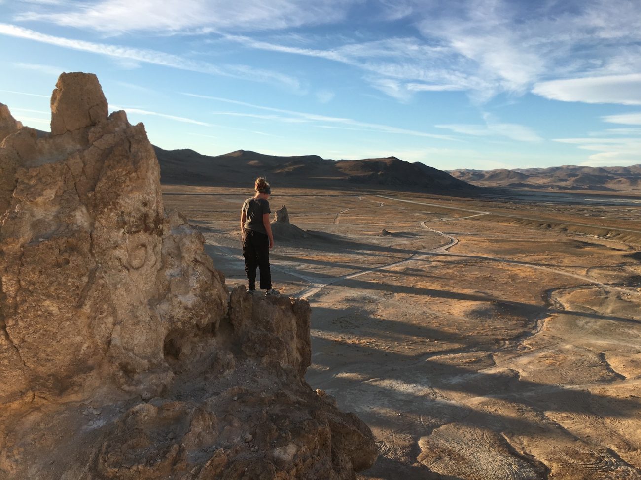 Girl on top of rock overlooking the desert