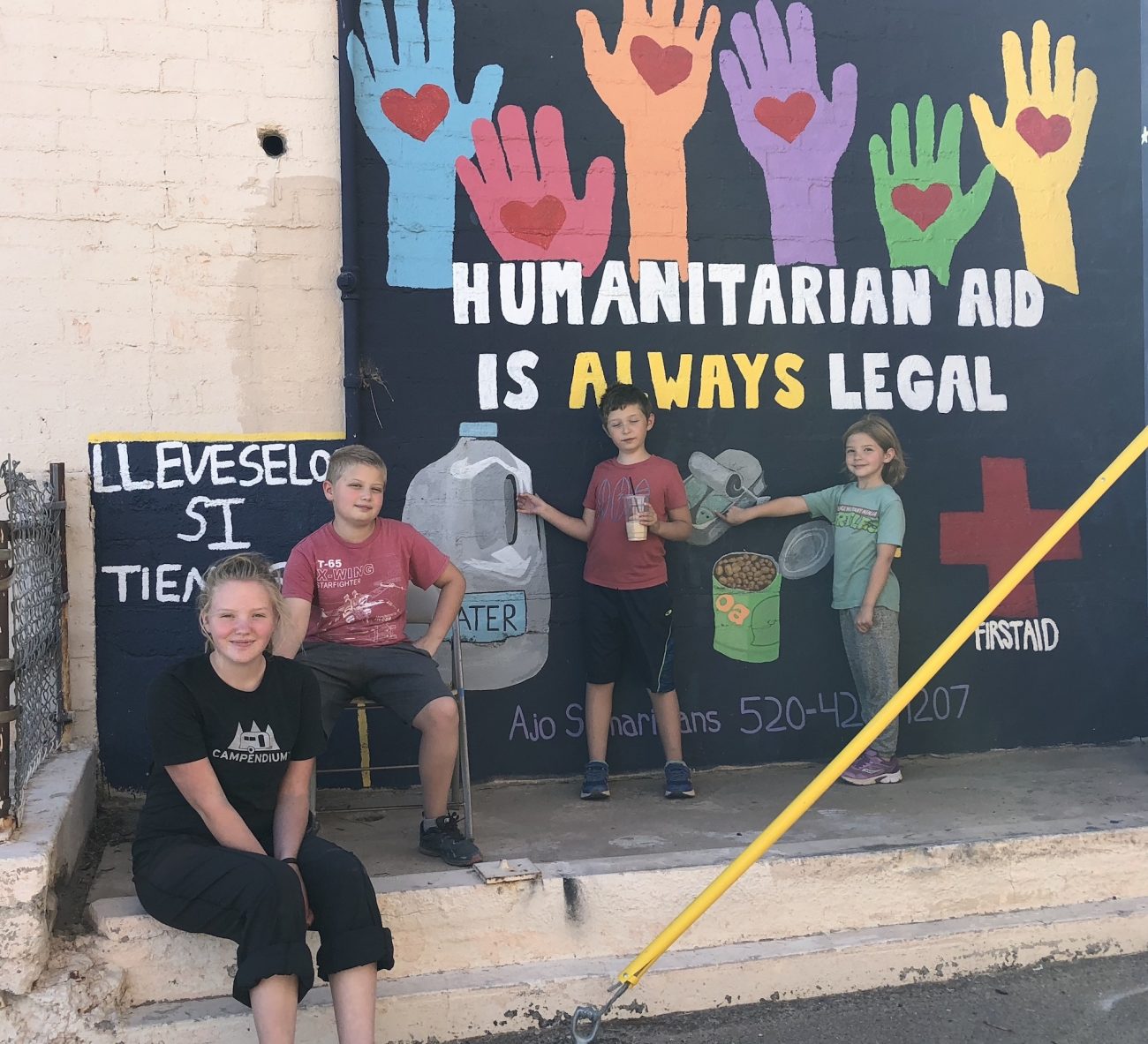Kids standing in front of mural for humanitarian aid in Ajo, AZ.