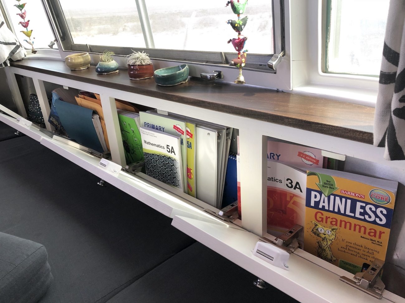 Front storage cabinets open with books inside