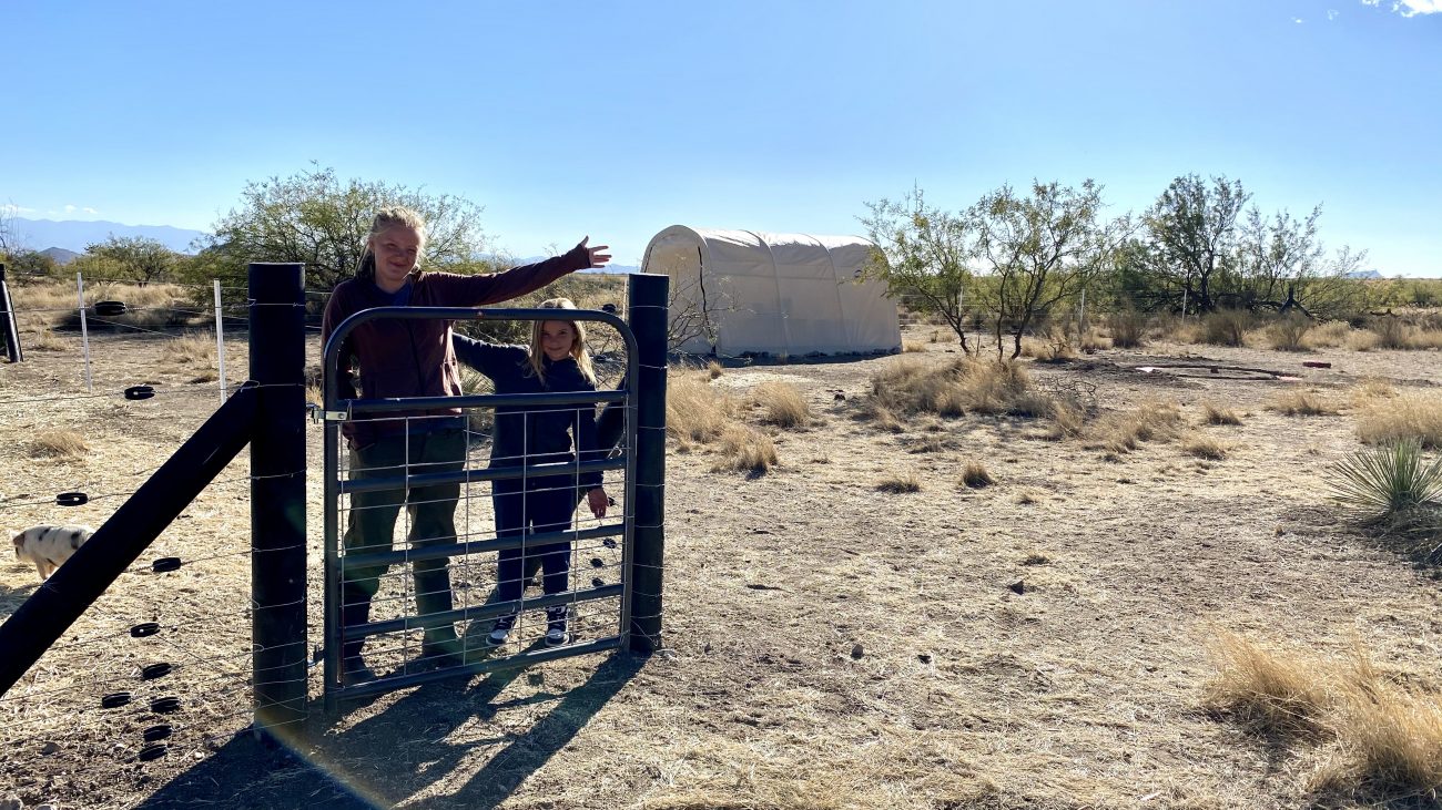 Adali and Ada standing in front of new pig paddock and feed shed.