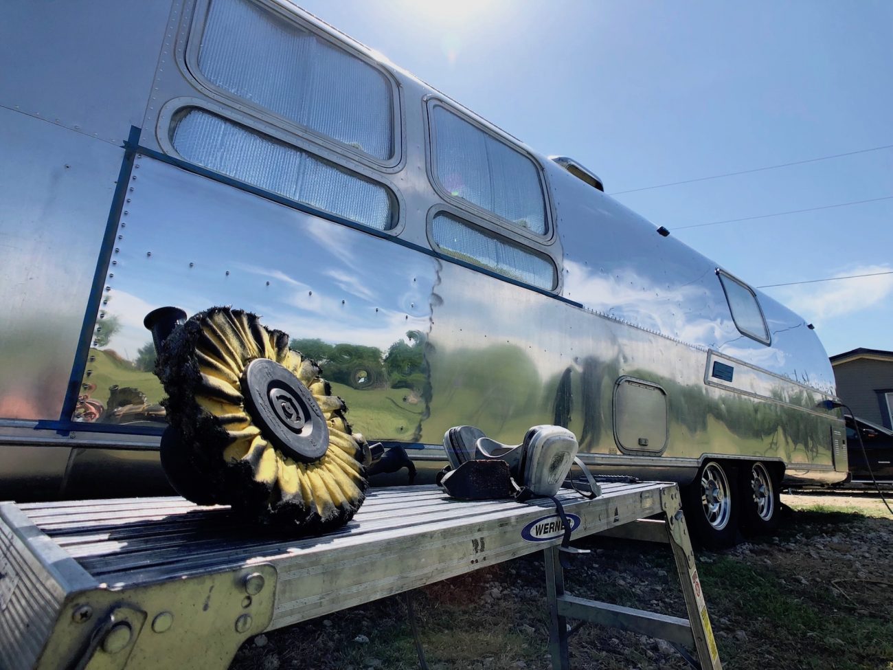 Polishing wheel in front of Airstream with a portion polished