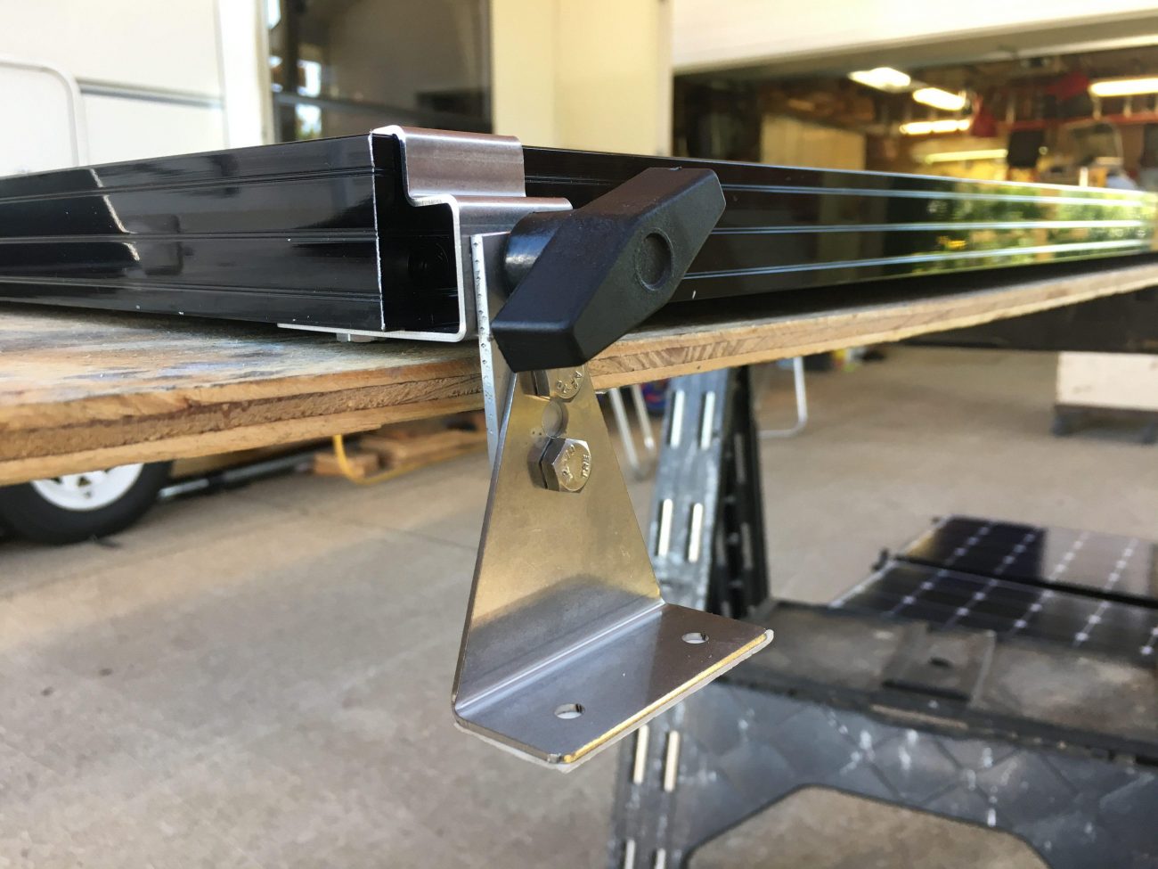 Mounting bracket for tilting solar panels on a vintage Airstream rounded roof.