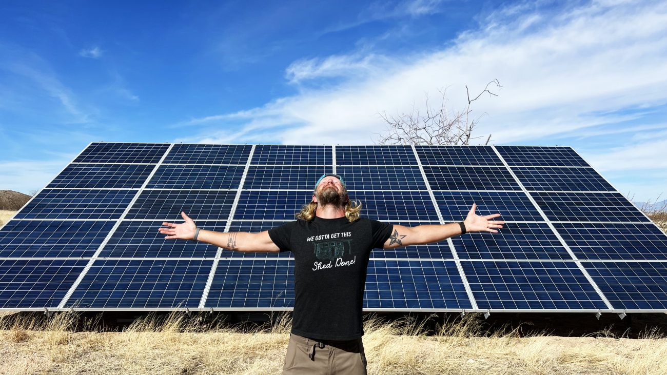 Man Standing in front of huge solar panel array